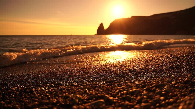 Abstract sea beach summer ocean sunset nature background. Sound of small waves on golden water surface in motion blur with golden bokeh lights from sun. Holiday, vacation and recreational concept.