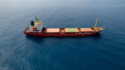 Large Red Cargo ship at sea with a Helipad