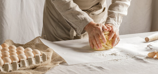 Women’s hands, flour and dough. A woman is preparing a dough for home baking. Concept of home...