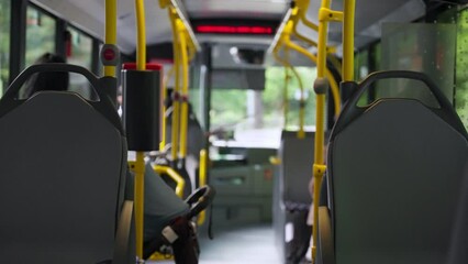 European bus ride from inside of vehicle driving through small suburban road. Green trees outside. No traffic with public transportation in city metropolitan. Vienna public bus in Austria