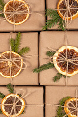 Christmas or New Year's background from boxes in craft paper with dried oranges, spruce branches and twine close-up. Concept Zero waste, eco friendly Merry Christmas. Top view Flat lay