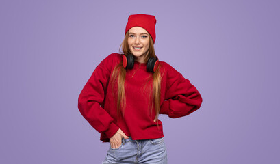 Delighted teenage lady smiling at camera in violet studio