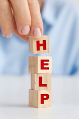 Businesswoman holding wooden block, HELP concept.