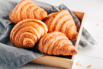 Fresh croissants, jam and coffee on white wooden table. Close up.