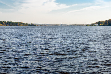 A pond with a forest along the shore on an autumn day