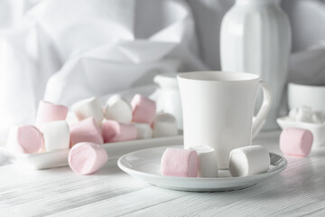 Pink and white marshmallows on a white table.