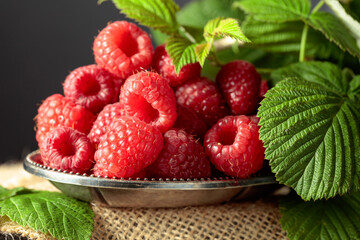 Raspberries in a small metal dish.