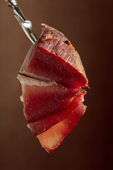 Dry-cured pork fillet on a fork.