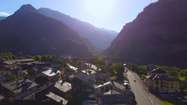 Italian alps village on a sunny day, aerial drone view with right motion