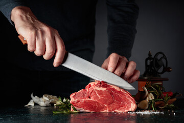 Chef cutting raw beef meat. - obrazy, fototapety, plakaty