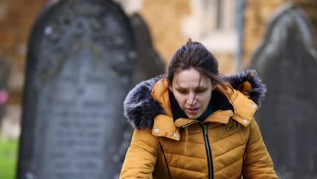 Young girl running scared through church cemetery graveyard and hiding