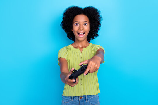Photo of little funky excited teenager addicted user playing new video game carefree shocked new image quality isolated on bright blue color background