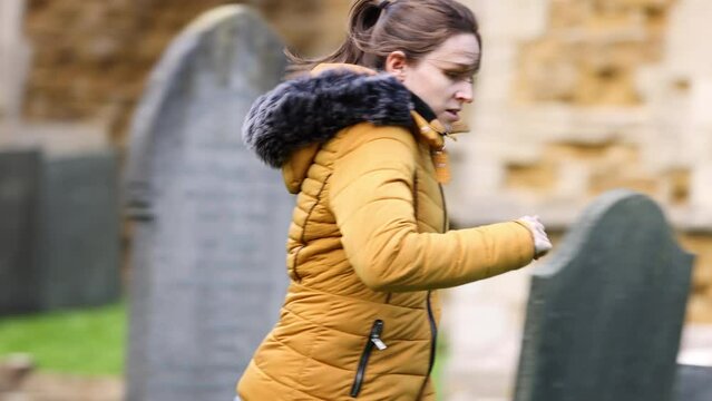 Young girl running scared through church cemetery graveyard