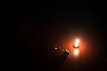 light bulb and candle on black background