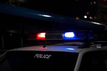 Obraz na płótnie Canvas Emergency light of police patrolling car on street in night