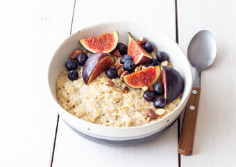 Oatmeal porridge with figs, blueberries, almonds and honey. Healthy eating. Vegetarian food. Breakfast.