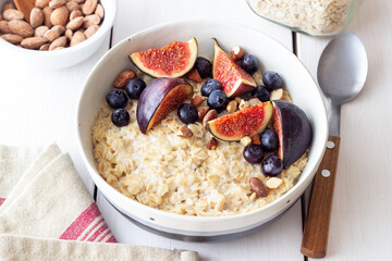 Oatmeal porridge with figs, blueberries, almonds and honey. Healthy eating. Vegetarian food. Breakfast.