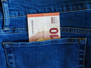 One Ten Euro Note in back pocket of blue denim jeans. 10 Euro banknote close up. Pocket money...