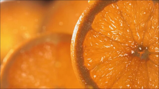 Drop of Orange Juice flows down the surface of a ripe juicy Orange slice. Slow Motion 4K