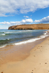 Baikal Lake. Olkhon Island in autumn. Sandy beach of Small Sea on a windy sunny day in October. Beautiful seascape.  Autumn travel and outdoor recreation