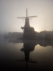 Windmill de Adriaan on a misty morning on the Spaarne River in Haarlem in the Netherlands