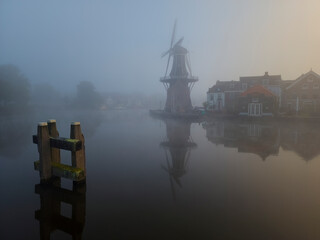 Windmill de Adriaan on a misty morning on the Spaarne River in Haarlem in the Netherlands