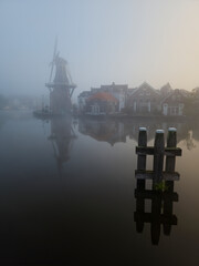 Windmill de Adriaan on a misty morning on the Spaarne River in Haarlem in the Netherlands