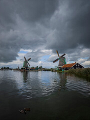 Windmills in Zaanse Schans in the Netherlands with reflections over the water