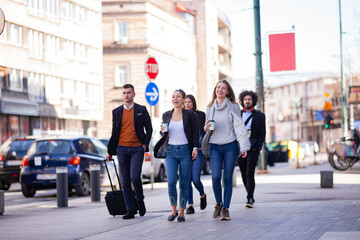 Group of people walking on a street with confidence. Businessmen and businesswomen traveling together..