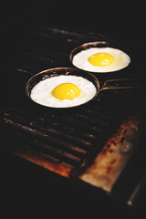 chef cooking Eggs in pan on grill in kitchen