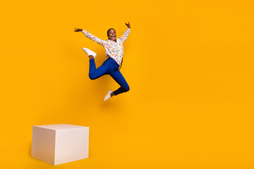 Fototapeta na wymiar Full length body size view of attractive cheery girl jumping from stage stretching twine isolated over bright yellow color background