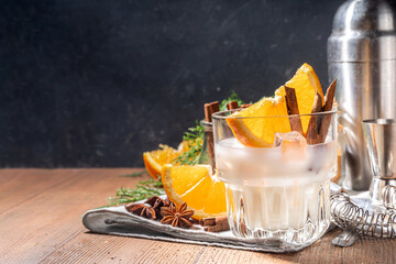 Autumn alcohol drink, boozy refreshing milk and honey cocktail with benedictine orange and cinnamon spice, wooden kitchen table background copy space - obrazy, fototapety, plakaty