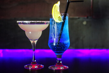 delicious creative bright cocktails booze alcohol with a straw are on the table in a club or a lighted bar