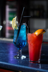 delicious creative bright cocktails booze alcohol with a straw are on the table in a club or a lighted bar