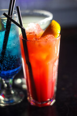 delicious creative bright cocktails booze alcohol with a straw are on the table in a club or a lighted bar