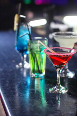 delicious creative bright cocktails booze alcohol with a straw are on the table in a club or a lighted bar
