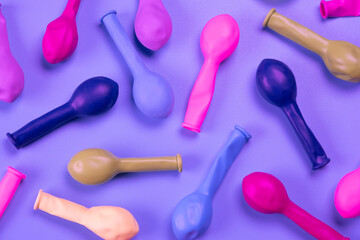 multi-colored balloons on a purple background, top view, the concept of celebrating a birthday, party or anniversary