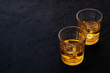 Glass of strong alcoholic drink whiskey with ice. Alcohol background