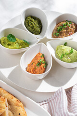 Israeli snack set - matbucha with eggplant, guacamole, edamame bean hummus, tuna rillette, olive and anchovy tapenade