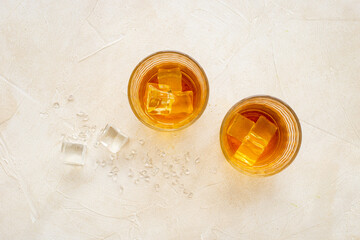 Golden whiskey in glass with ice. Strong alcohol background