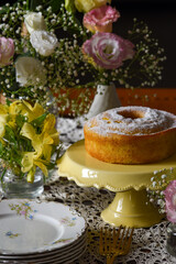 Bolo de fubá com cobertura de açúcar em ambiente decorado com flores