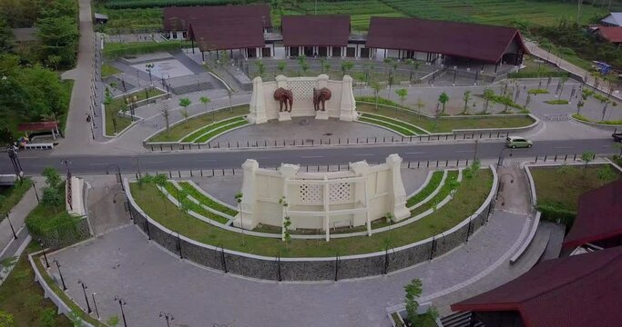 Drone shot above kembang Linus gate of Borobudur temple while driving cars on road