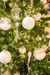 White ball and crystal decorations on green fir. Happy New Year and Xmas theme