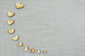Heart made of wood on a gray background. Beige texture background. Natural cotton burlap.