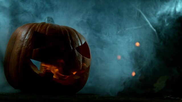 Scary Pumpkin Jack O Lantern with Flaring Candles. Halloween Background. Super Slow Motion Filmed on High Speed Cinema Camera at 1000 fps.