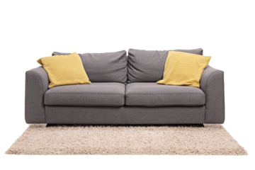 Studio shot of a grey sofa with green pillows on a carpet