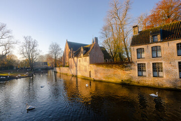 Naklejka na ściany i meble Beautiful old town , canals and medieval buildings of Brugge during autumn , winter sunny day : Brugge , Belgium : November 30 , 2019