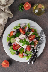 Classic Greek salad from tomatoes, cucumbers, sweet pepper, olives, basil and feta cheese, Top view