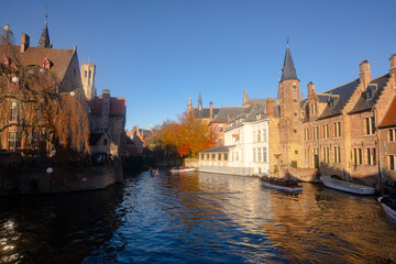 Fototapeta na wymiar Rozenhoedkaai in Brugge , panoramic view along the canal and medieval buildings in old town during winter sunny day : Brugge , Belgium : November 30 , 2019