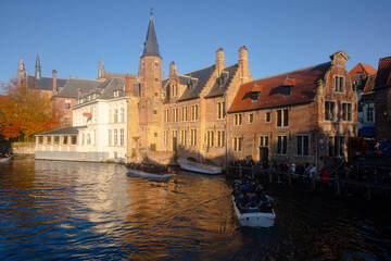 Naklejka na ściany i meble Rozenhoedkaai in Brugge , panoramic view along the canal and medieval buildings in old town during winter sunny day : Brugge , Belgium : November 30 , 2019